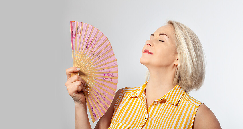 Attractive middle aged woman relaxing with fan. mature woman exp